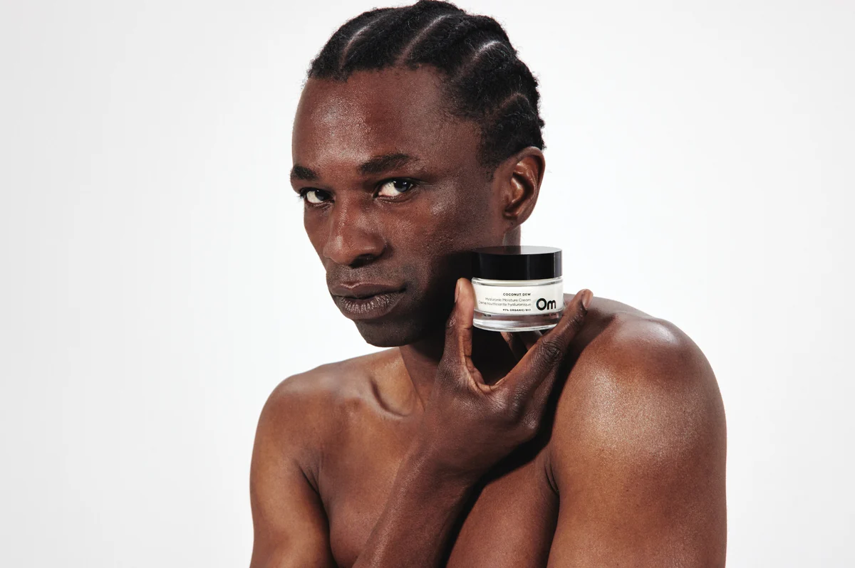 A model holding a jar of Coconut Dew beside their face